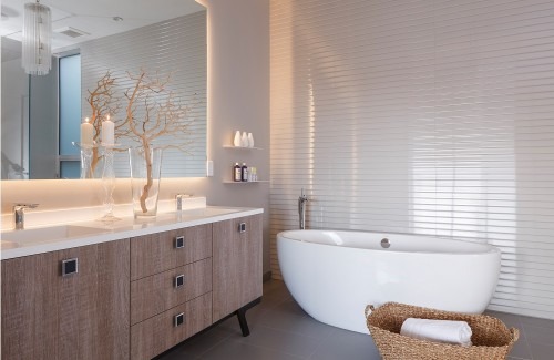 Luxurious bathroom featuring a freestanding white tub, wooden vanity with modern fixtures, and elegant decor, creating a serene spa-like atmosphere.